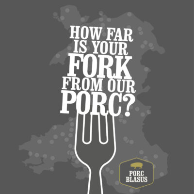 The image features a stylized white fork against a grey background. The text “HOW FAR IS YOUR FORK FROM OUR PORC?” is displayed within the outline of the fork. Below the text, there is a yellow logo with the words “PORC BLASUS” inside a pig-shaped outline. The overall design has a modern and playful feel.