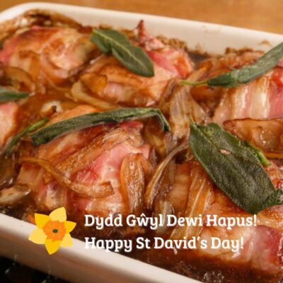 A delicious looking dish of food topped with herbs, with a greeting for St David’s Day in both Welsh and English at the bottom, accompanied by an illustration of a daffodil.
